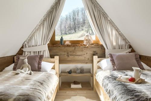 dwa łóżka w pokoju z oknem w obiekcie NA SKRAJU LASU domki z balią, jacuzzi w Białym Dunajcu