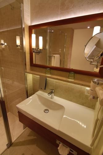 La salle de bains est pourvue d'un lavabo et d'un miroir. dans l'établissement IBB Hotel Ingelheim, à Ingelheim-sur-le-Rhin