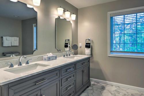 a bathroom with two sinks and a large mirror at Chic Lake Sinclair Retreat with Dock and Hot Tub! in Resseaus Crossroads