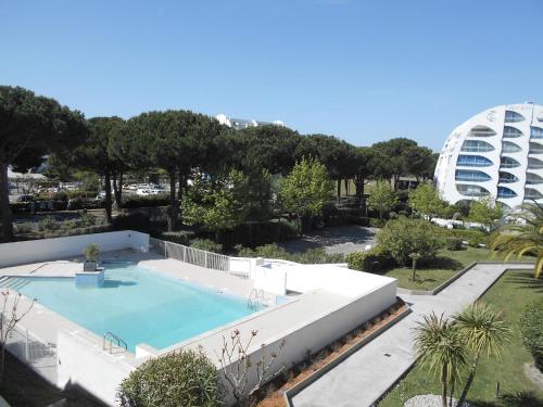 une grande piscine avec un bâtiment en arrière-plan dans l'établissement Vittoria Immobilier 6 -REGLEMENT SUR PLACE - chèques vacances acceptés, à La Grande Motte