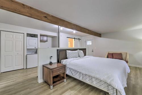 1 dormitorio con cama blanca y suelo de madera en Riverdale Studio about 18 Mi to Downtown Atlanta!, en Riverdale