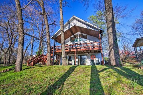 a house with a wrap around porch in the woods at Fire Pit and Boat Slip Waterfront Grove Getaway in Grove