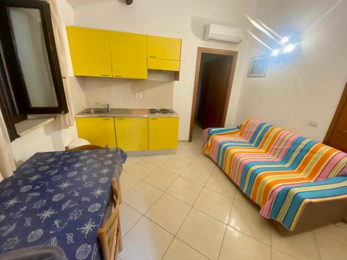 a kitchen with yellow cabinets and a couch in a room at Il Tombolo in Giannella
