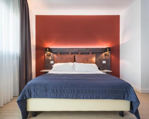 a bedroom with a blue bed with a red wall at Rivalta Life Style Hotel in Salò