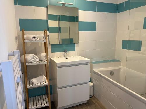 een badkamer met een wastafel, een spiegel en een bad bij Appart'hôtel La Suze sur Sarthe in La Suze-sur-Sarthe