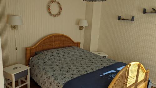 een slaapkamer met een bed met 2 tafels en 2 lampen bij Rêve Bleu in Duinkerke