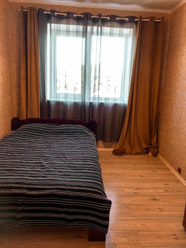 a bedroom with a bed in front of a window at Dzelmes in Kolka