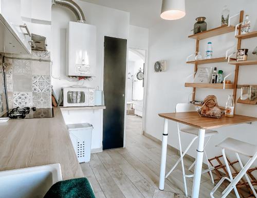 une cuisine avec une table et des placards blancs dans l'établissement Appartement T3 tout confort à 500m de la mer, à Saint-Cyr-sur-Mer