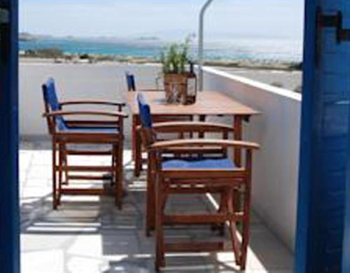 a table and chairs on a balcony with a view of the ocean at Koulas Pension - Red Lake in Agios Prokopios