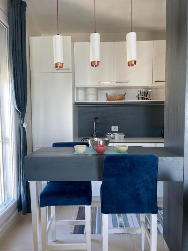 a kitchen with a table and two blue chairs at viki sea view apartment in Durrës