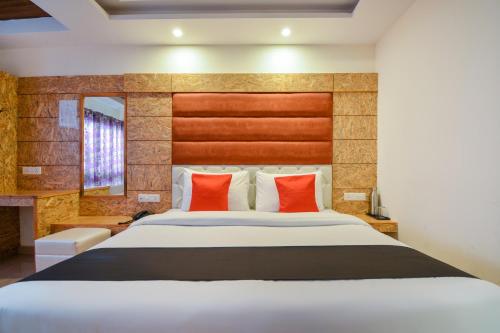 a bedroom with a large bed with red pillows at Hotel Valley Vista in Mussoorie