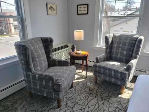 a living room with two chairs and a table at Little Fig Hotel in Bar Harbor
