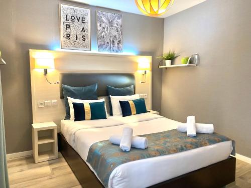 a bedroom with a large bed with two pillows at Hôtel Clairefontaine in Paris