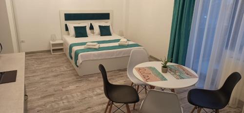 um quarto com uma cama, uma mesa e cadeiras em Studio Maya em Năvodari