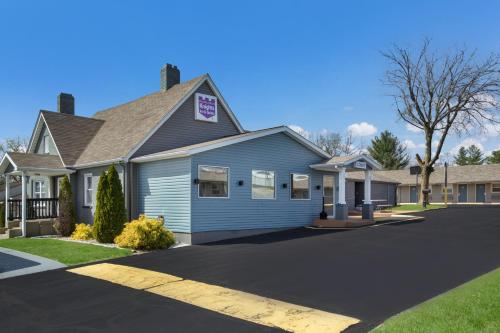 a blue house with a driveway in front of it at Knights Inn and Suites Salem in Salem