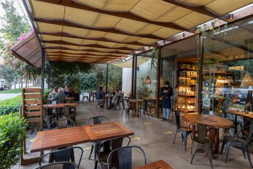 un patio con mesas y sillas de madera y una librería en The Place en Santiago