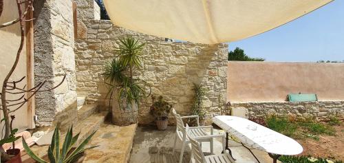 a patio with a table and chairs and an umbrella at Aelia in Kamilari