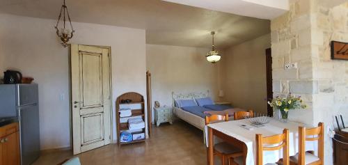 a room with a table and a kitchen with a bed at Aelia in Kamilari