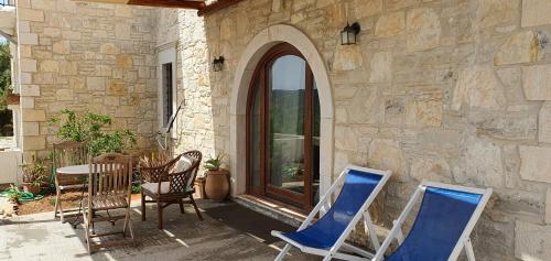 two chairs and a table on a patio at Aelia in Kamilari