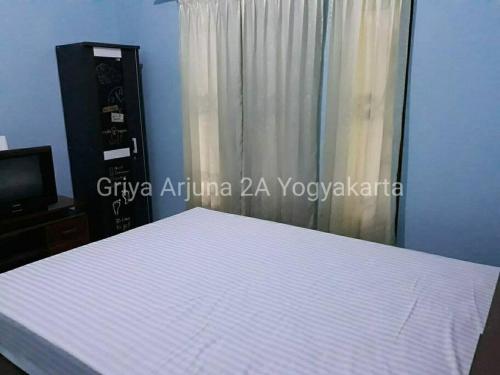 um quarto com uma cama branca e uma janela em Griya Arjuna 2A em Ngabean