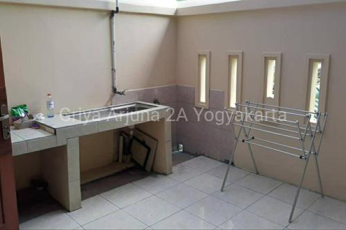 ein Bad mit einem Waschbecken und einem Spiegel in der Unterkunft Griya Arjuna 2A in Ngabean