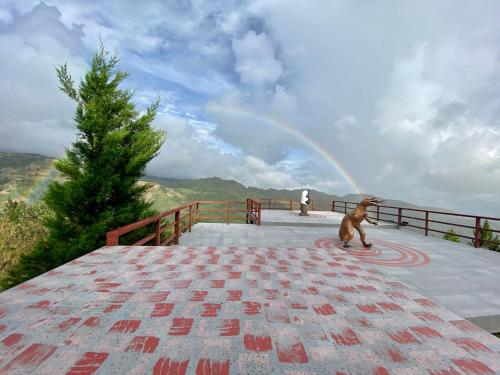 a dog riding a skateboard with a rainbow in the background at JR RESORT in Ranau
