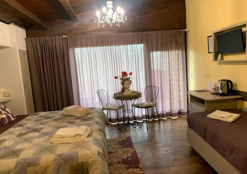 a bedroom with a bed and a table and chairs at B&B Villa del Sole Relais in Agrigento