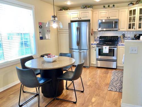 a kitchen with a table with chairs and a refrigerator at The Comforts' Inn: Mountain Escape in Mountainaire