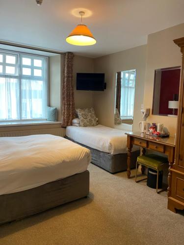 a hotel room with two beds and a desk at The Lantern Townhouse in Dingle