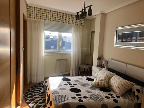 1 dormitorio con cama y ventana en Apartamento La Barrosa, en Sada