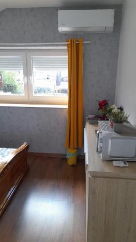 Cette chambre comprend un lit et un rideau jaune. dans l'établissement Studio privée Vesoul -Wifi,TV,Clim,Parking gratuit, à Vesoul
