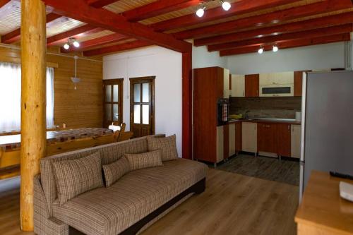 a living room with a couch and a kitchen at Bucsin Kulcsosház in Joseni