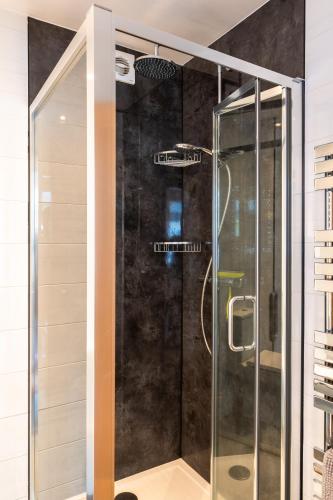 a shower with a glass door in a bathroom at Finest Retreats - Tinners Rest in St Austell