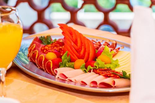 a plate of food with meat and vegetables on a table at Rooms and Restaurant Danica in Povile