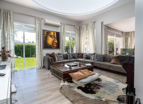 a living room with a couch and a table at Villa Happy River in Marbella