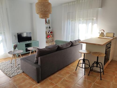uma sala de estar com um sofá e uma mesa em O'Eirado Playa de Quenxe em Corcubión