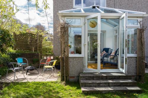 a conservatory on the side of a house with chairs at Finest Retreats - Tinners Rest in St Austell