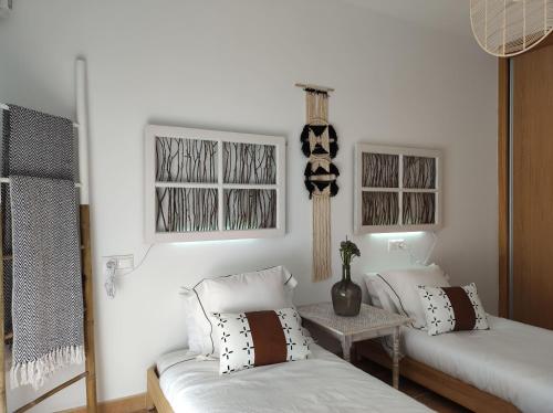 a living room with two white couches and a table at O'Eirado Playa de Quenxe in Corcubión