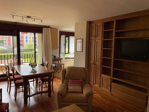 a living room with a table and chairs and a television at Camino al Cuera in Llanes