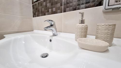 - un lavabo avec robinet et une bouteille de savon dans l'établissement Residenza Magnolia, à Tropea