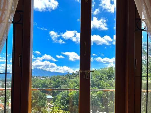 a window view of a blue sky and trees at Hansons Homestay in Kandy