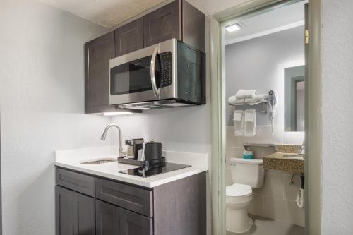 uma pequena cozinha com um lavatório e um micro-ondas em Knights Inn & Suites Salem em Salem