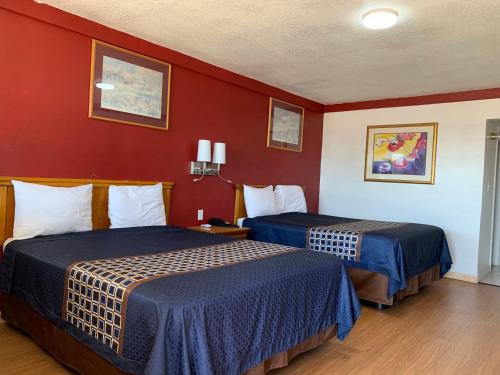 two beds in a hotel room with red walls at Budget Inn in Memphis