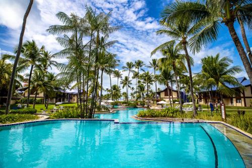 una piscina en el complejo con palmeras en Summerville Resort - All Inclusive, en Porto de Galinhas