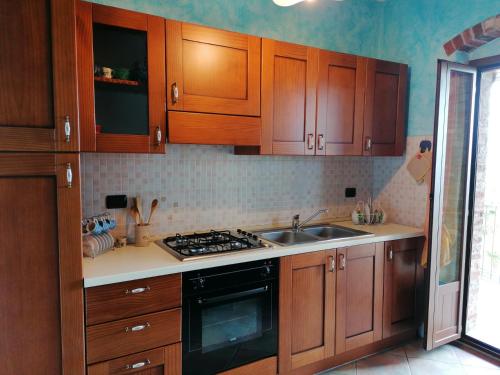 - une cuisine avec des placards en bois et un évier dans l'établissement Cascina Zanot, à Marsaglia