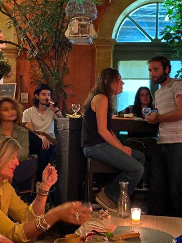a group of people sitting around a table with wine glasses at Rue du Château in Tarascon