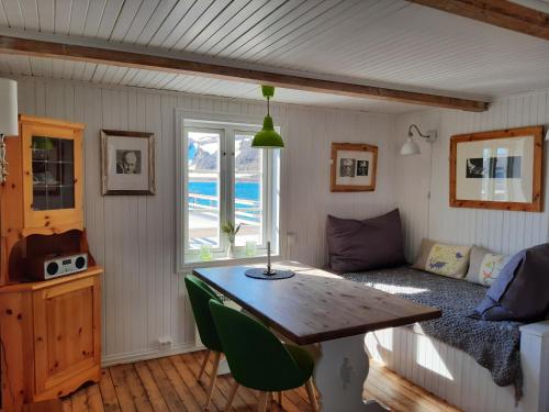 een kleine kamer met een tafel en een bank bij Lovisenborg Brygge in Kongsfjord
