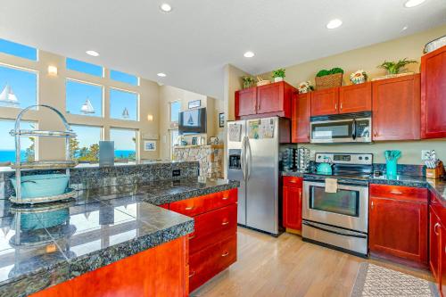 a kitchen with red cabinets and stainless steel appliances at Wind 'N Sails in Pacific City