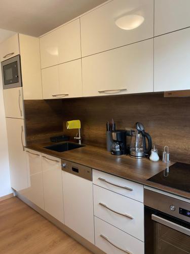 a kitchen with white cabinets and a counter top at Ferienhaus Butterfly 2 in Garmisch-Partenkirchen