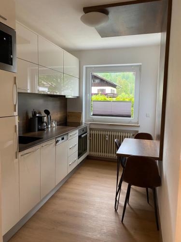 a kitchen with white cabinets and a table and a window at Ferienhaus Butterfly 2 in Garmisch-Partenkirchen